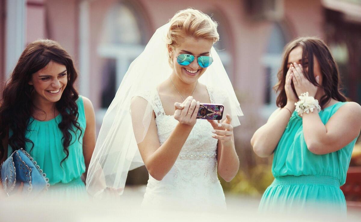 Beautiful gorgeous happy blonde bride with bridesmaids on the street on the background restaurant